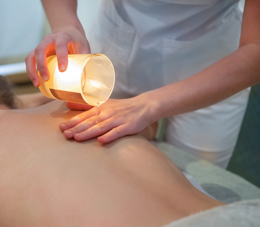 Young Woman Getting Spa Massage with Massage Candle